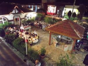 a group of people sitting at tables in a yard at night at Hamsilos Apart Hotel in Sinop