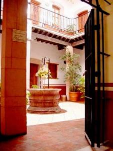 an open door to a courtyard with a fountain at Hotel Reyna Soledad in Zacatecas