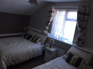 um quarto com 2 camas e uma janela em Coolalingo B&B em Drumgoff Bridge