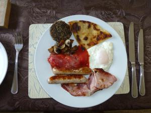 a plate of breakfast food with eggs sausage and bread at Cairndoon Byre in Monreith