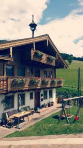 a building with a table and benches in front of it at Onemooshof in Maria Alm am Steinernen Meer