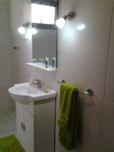 a white bathroom with a sink and a mirror at Tanana Maeva in Antananarivo