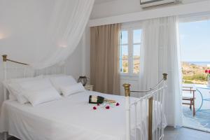 um quarto branco com uma cama branca e uma janela em To Maro em Kástron