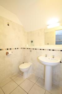 a white bathroom with a toilet and a sink at Ballater Hostel in Ballater