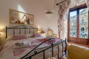 a bedroom with a bed and a large window at Palazzotto in Ostuni