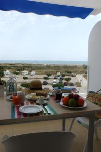 een tafel met eten erop met uitzicht op een parkeerplaats bij Pérola do Oceano in Manta Rota