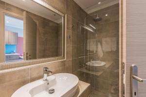 a bathroom with a sink and a shower and a mirror at Pansion Ermioni in Skala