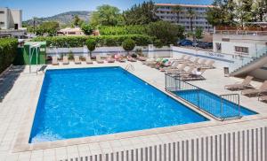 a swimming pool with lounge chairs and a hotel at Apartamentos Sol y Vera in Magaluf
