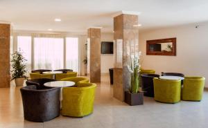 a lobby with yellow stools and tables and chairs at Apartamentos Sol y Vera in Magaluf