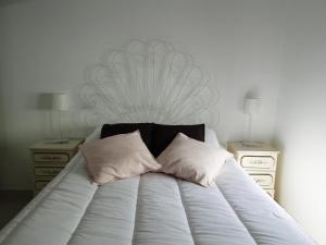 een bed met 2 kussens en 2 nachtkastjes bij Casa São José by Pérola do Oceano in Manta Rota +4 foto's