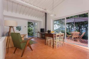 a kitchen and dining room with a table and chairs at Quinta dos Peixes Falantes in Ribeira Grande