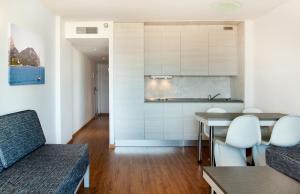ein Wohnzimmer mit einem Tisch und einer Küche in der Unterkunft Apartamentos Sol y Vera in Magaluf