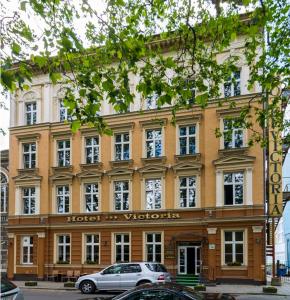 ein Gebäude mit einem davor geparkt in der Unterkunft Hotel Victoria in Stettin