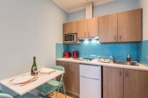 a kitchen with a sink and a table with chairs at Pansion Ermioni in Skala