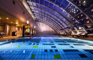 a large indoor swimming pool with a large ceiling at Hotel New Otani Makuhari in Chiba
