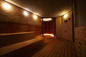una sauna con panche e luci su un muro di mattoni di Hotel New Otani Makuhari a Chiba