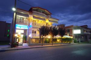 un grand bâtiment avec des lumières sur le côté d'une rue dans l'établissement John & Eve Hotel, à Paralia Katerinis