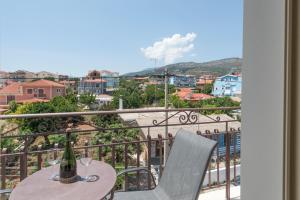 a table with a bottle of wine on a balcony at Pansion Ermioni in Skala