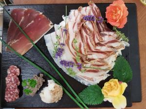 a plate of food with meats and flowers on it at Biohof Hausberg in Egglham