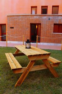 カランブローネにあるAppartamento vicino alla spiaggiaのレンガ造りの建物の前の芝生の木製のピクニックテーブル
