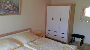ケルピンセにあるFerienhaus Koelpinsee USE 2221のベッドルーム1室(ベッド1台、ドレッサー、クローゼット付)