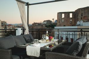 a patio with a table and chairs on a balcony at Nival Luxury Suites in Chania