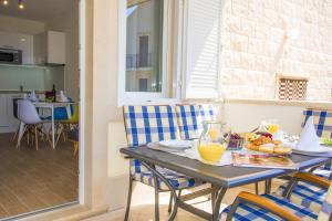 a table with a bowl of orange juice on it at Eni apartments BOL in Bol