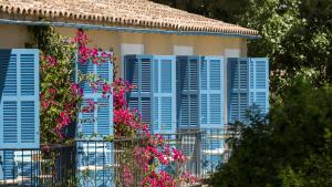 una casa con persianas azules y flores en ella en Finca Son Miranda - LA Organic, en Sencelles