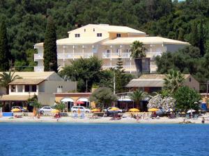 un hotel en una playa con gente sentada en la arena en Ipsos Beach Hotel, en Ýpsos