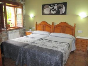 Casa Rural El Jondrigu في كانغاس دي أونيس: غرفة نوم بسرير كبير في غرفة