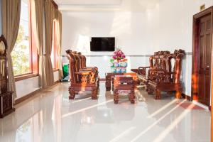 sala de estar con sillas, mesa y TV en Hoa An Hotel, en Rạch Giá