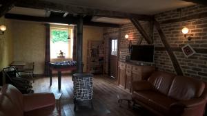 a living room with a couch and a tv at Vakantiehuis Le Colombage in Beauraing