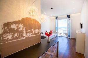 ein Wohnzimmer mit einer Vase mit Blumen auf einem Tisch in der Unterkunft Cefalù Charme e Chic Suites in Cefalú