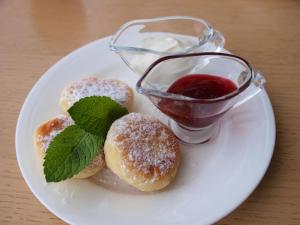 a plate with two donuts and a glass of red sauce at Hotel Nika 2 in Chornomorsk