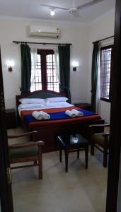 Elim Homestay Fort Kochi في كوتشي: غرفة نوم بسرير كبير مع ستائر خضراء