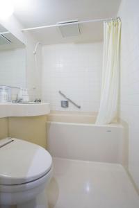 a white bathroom with a toilet and a sink at Tetoranze Makuhari Inagekaigan Hotel in Chiba