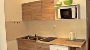 a small kitchen with a sink and a microwave at Apartament u Magdy in Międzyzdroje