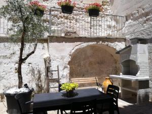 a table and chairs in a courtyard with a stone wall at Sassi Sotto Le Stelle in Matera