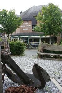 a statue of a anchor sitting on a sidewalk in front of a building at Hotel Lommel Broek in Kerkhoven