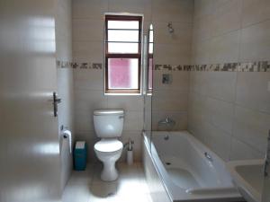 a bathroom with a toilet and a tub and a sink at Melville Turret Guesthouse in Johannesburg