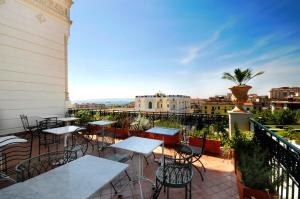 eine Terrasse mit Tischen und Stühlen auf dem Balkon in der Unterkunft Villa Battista in Ercolano