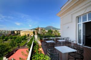 balcón con mesas y sillas y vistas a la ciudad en Villa Battista, en Ercolano