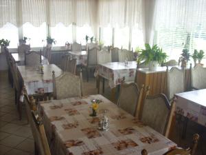 a dining room with tables and chairs and windows at Hotel Europa in Holsthum