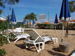a group of lawn chairs and umbrellas on a beach at La Marina Bay in Vieste