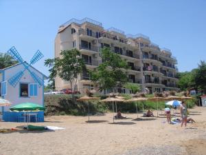 a group of people on a beach with umbrellas at Villa Lazuren Bryag in Chernomorets