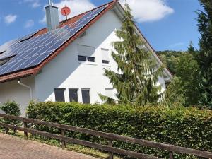 a white house with solar panels on the roof at Ferienwohnung Wegst in Schweigen-Rechtenbach