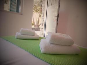 two stacks of towels sitting on a green carpet at Rossi's Studios in Moraitika