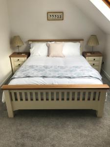 1 dormitorio con 1 cama grande y 2 mesitas de noche en Daedalus Bed & Breakfast, en Muir of Ord