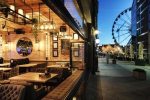 a restaurant with tables and chairs and a ferris wheel at Apartamenty Chleb i Wino in Gdańsk