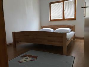 a bedroom with a bed with two pillows and a window at Apartment near the Airport in Sarajevo